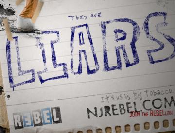 A torn and crumpled sticker with "LIARS" written in purple text on a white background.