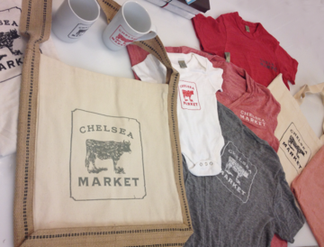 Fabric samples and a Chelsea Market branded tote bag with cow logo.