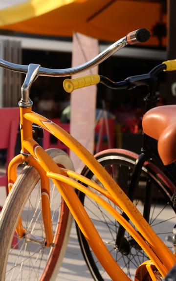 Orange bicycle parked against a colorful background.